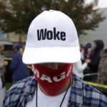 A supporter of President Donald Trump wears a "Woke" hat before a campaign rally at Lancaster Airport, Monday, Oct. 26, 2020 in Lititz, Pa. (AP Photo/Jacqueline Larma)